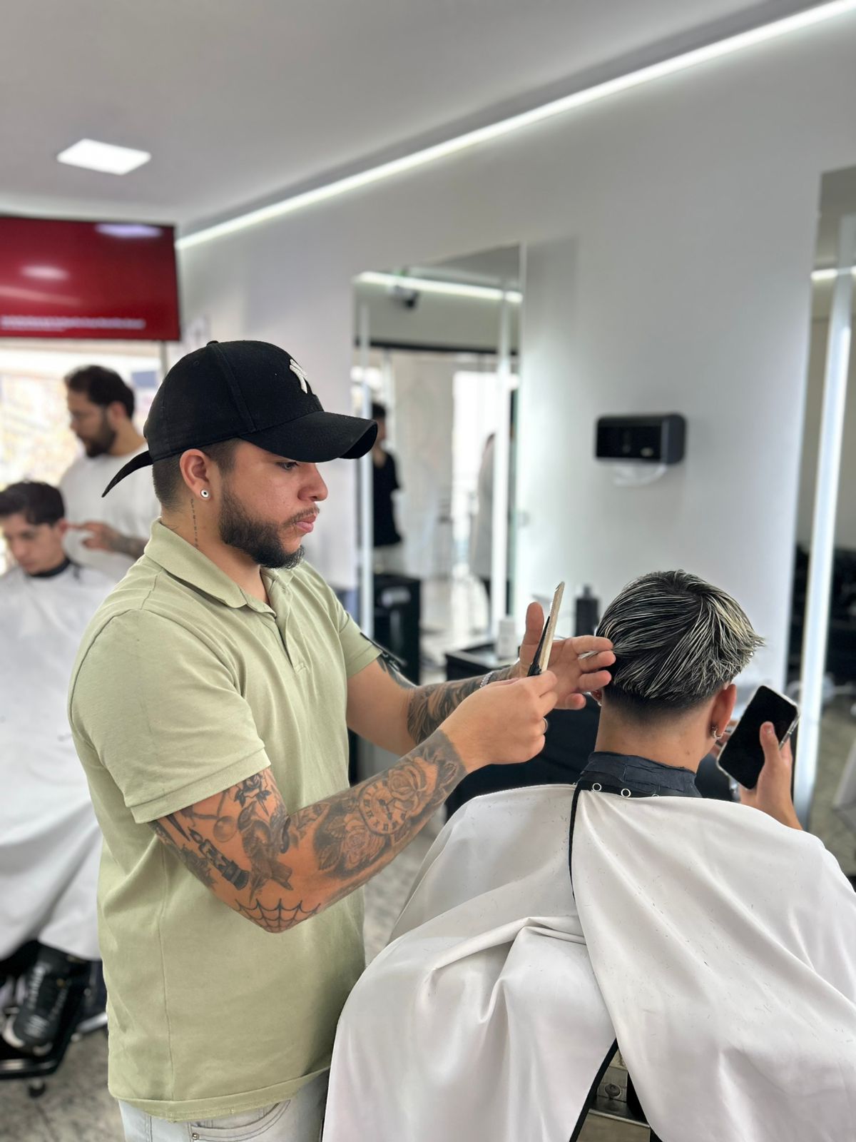 Barbeiro realizando corte com técnica profissional